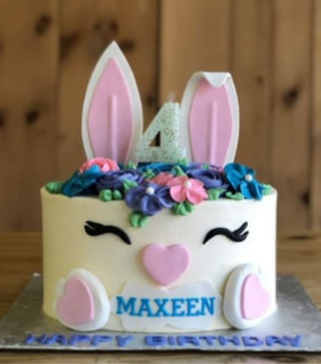 Gâteau d'anniversaire sur mesure des 4 ans de Maxeen: gâteau à thématique de tête de lapin avec une couverture à la crème au beurre et décoré d'oreilles et de pattes en fondant et de fleurs en sucre.