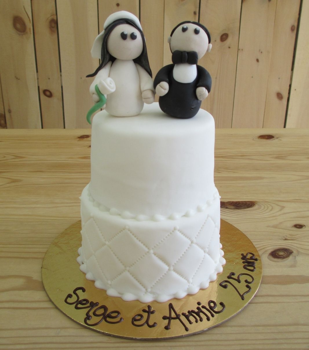 Gâteau d'anniversaire de mariage des 25 ans de Serge et Annie: petit gâteau de 2 étages avec une couverture au fondant blanc et décoré de figurines de mariés simples en fondant sculptées à la main.