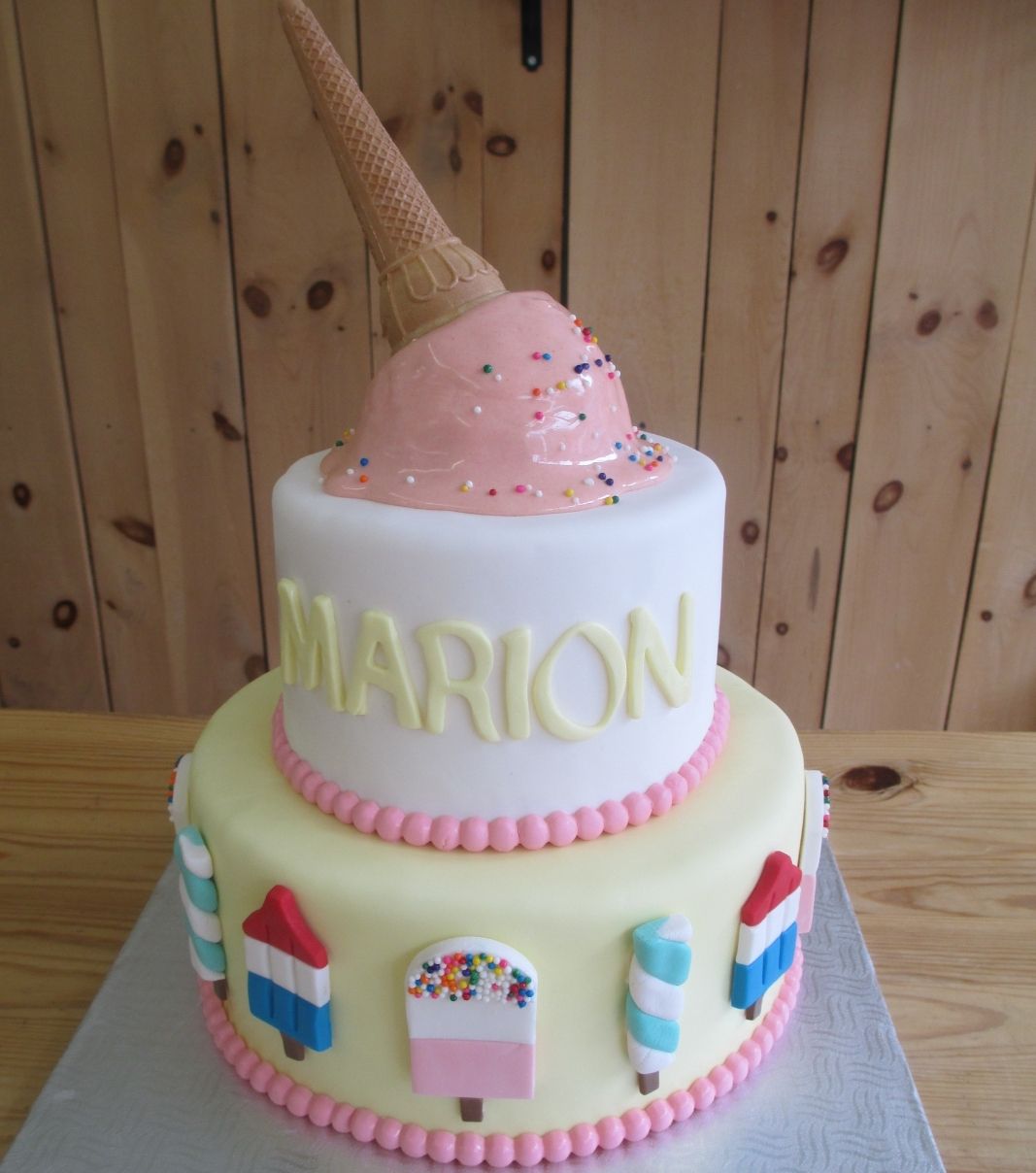 Gâteau shower de bébé fille de Marion: gâteau à la crème glacée de 2 étages avec un cornet dégoulinant, des sucettes glacées 2D et une couverture fondante.