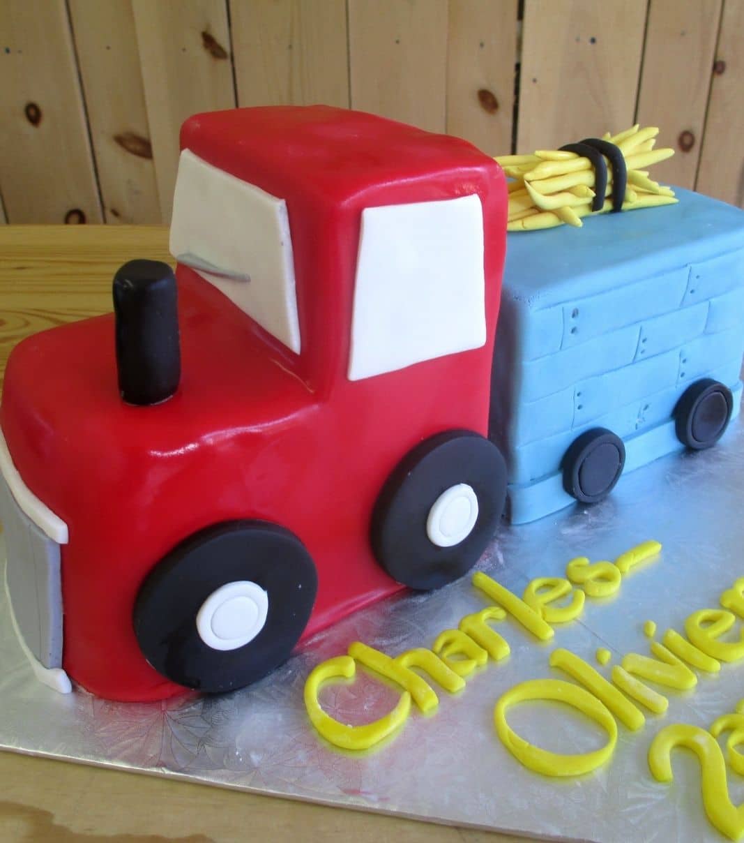 Gâteau d'anniversaire sur mesure des 2 ans de Charles-Olivier: gâteau 3D à thématique camion avec une couverture en fondant et décoré de foin en fondant.