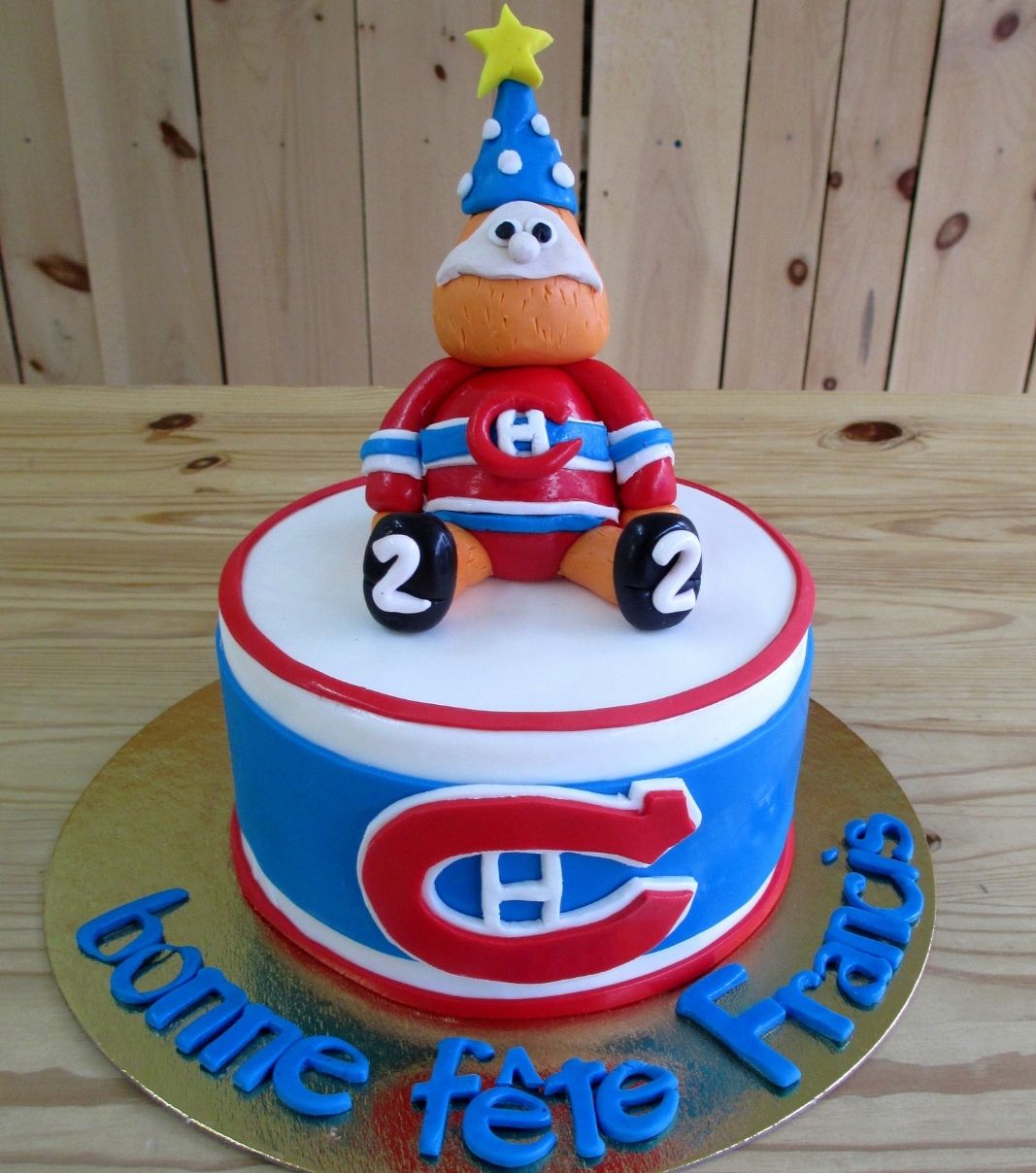 Gâteau d'anniversaire sur mesure des 2 ans de Françis: gâteau à thématique Canadiens de Montréal avec une couverture en fondant bleu, blanc et rouge et décoré d'une figurine 3D de Youppi.