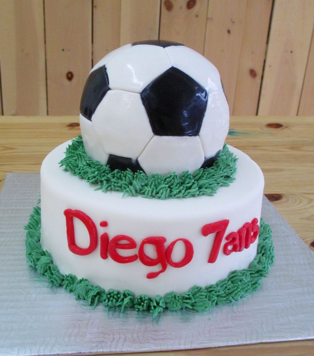 Gâteau d'anniversaire sur mesure des 7 ans de Diego: gâteau de 2 étages avec un ballon de soccer 3D et décoré d'une bordure de gazon en crème au beurre.