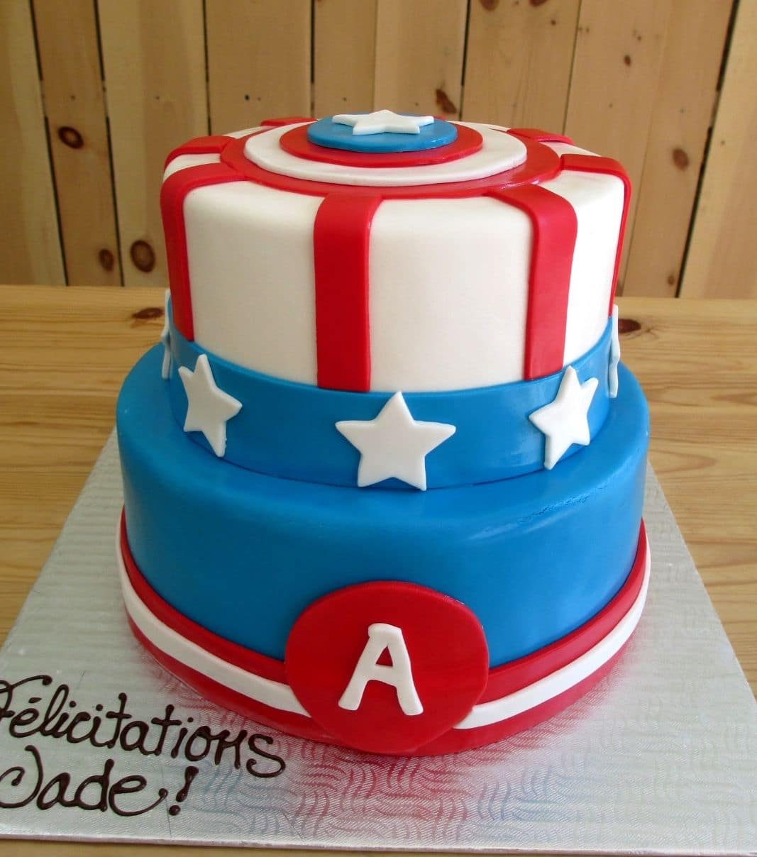 Gâteau d'anniversaire sur mesure de Jade: gâteau de 2 étages à thématique de Capitaine America avec une couverture en fondant blanc, rouge et bleu.