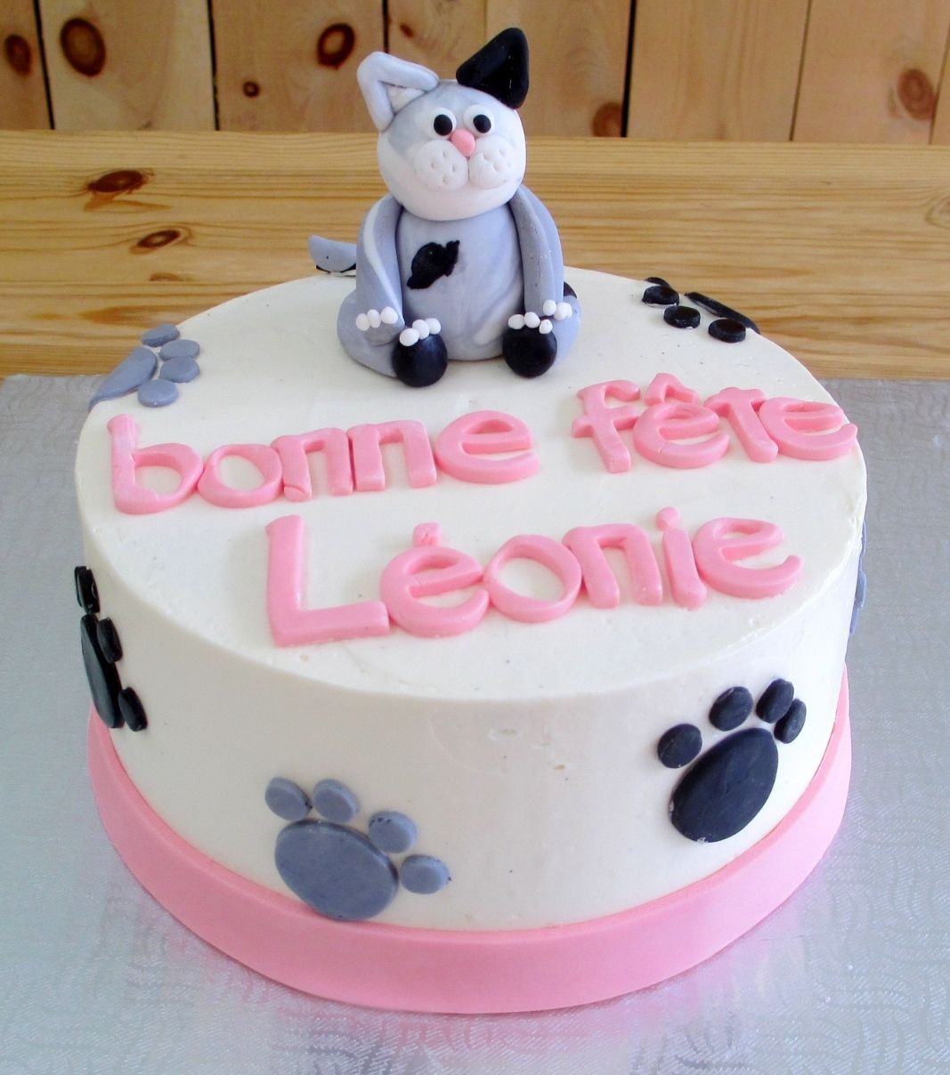 Gâteau d'anniversaire sur mesure de Léonie: gâteau à thématique de chat avec une crème au beurre et décoré d'une figurine de chat et de pattes de chat en fondant.