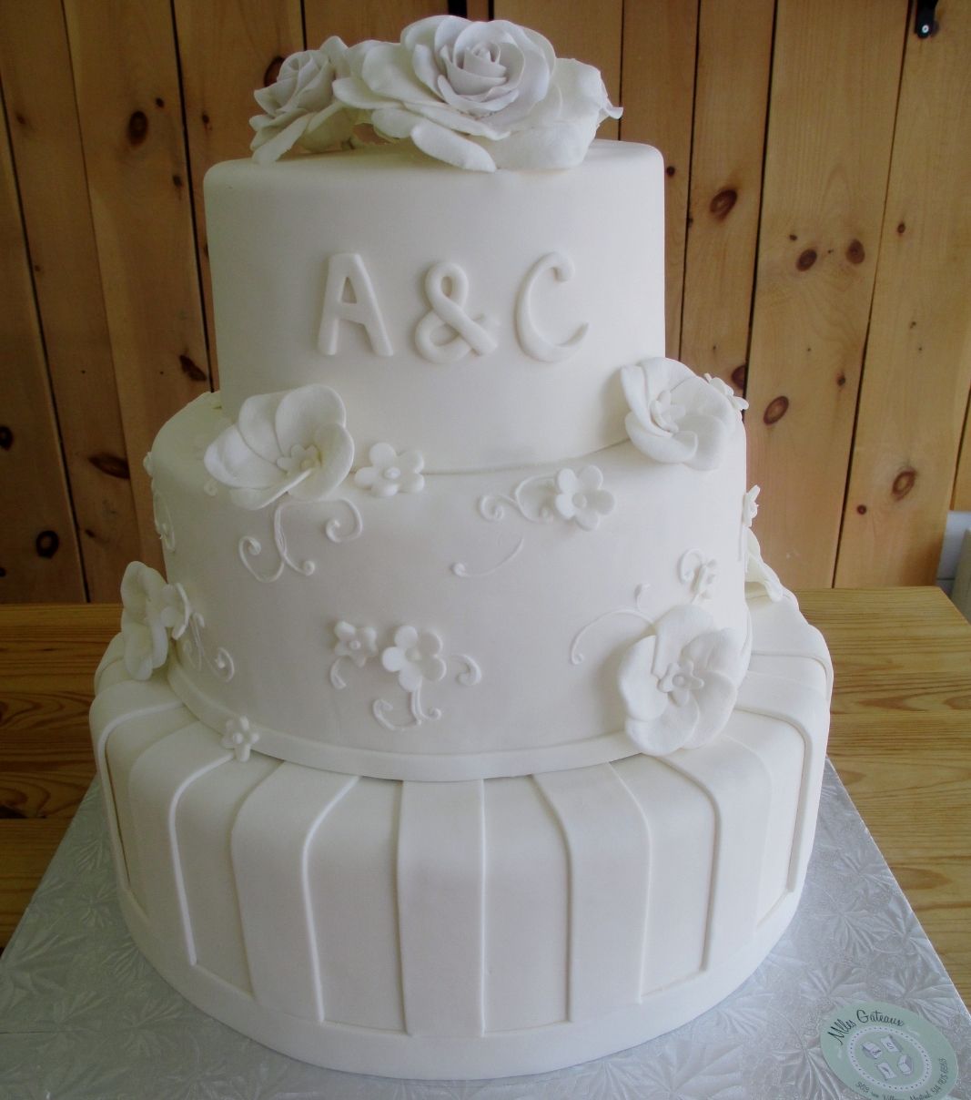 Gâteau de mariage: gâteau de 3 étages à thème blanc sur blanc, avec une couverture fondante et décoré de roses en sucre et de fleurs en sucre texturées.