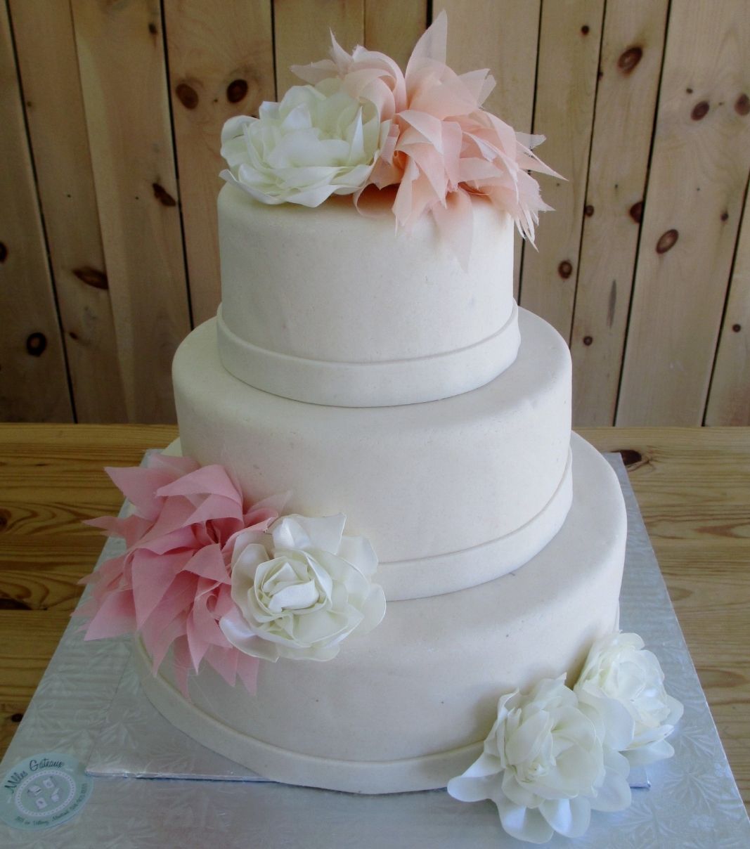 Gâteau de mariage d'Elisabeth et Dennis: gâteau de 3 étages avec une couverture en pâte d'amande naturelle et décoré de fleurs en tissus pastels.