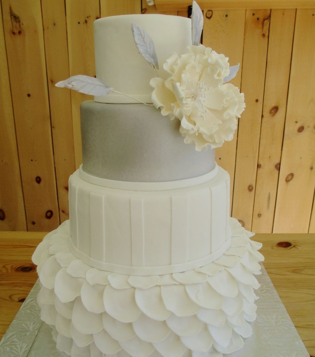 Gâteau de mariage de Francine et Simon: gâteau de 4 étages à thème blanc et argenté avec une texture de pétales et décoré de grosses fleurs en sucre.