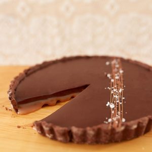 Image de la tarte chocolat et caramel fleur de sel de Mlles Gâteaux : Pâte sucrée au chocolat garni de notre caramel fleur de sel et surmonté d'une ganache au chocolat noir.