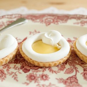 image de la tartelette au citron meringué de Mlles Gâteaux : Crème citron monté au beurre sur une croûte de pâte sucrée à la vanille garnie de meringue italienne et céréales croustillantes au chocolat blanc