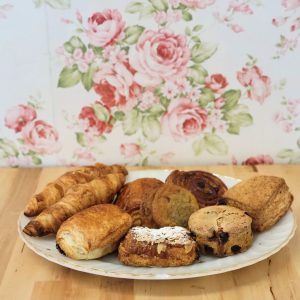 Assiette de viennoiseries : 2 croissants, 2 chocolatines, 2 biscuits au chocolat, 1 danoise raisin, 1 amandine nature ou chocolat, 1 scones cheddar et herbes et 1 scones au bleuet.