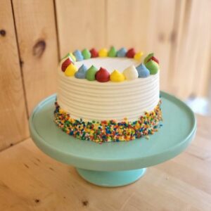 Découvrez notre gâteau d'anniversaire funfetti avec crème au beurre coloré et bordure de bonbons multicolores