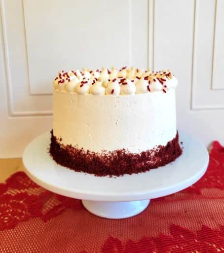 Découvrez notre gâteau rouge velours de 12 parts. Il est masqué de crème au beurre blanche et a une bordure de poudre de gâteau rouge velours à sa base.