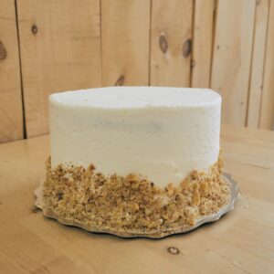 Gâteau à la carotte rustique composé de trois étages de notre célèbre gâteau à la carotte, garnis de mousse au fromage à la crème et d’un confit d’ananas vanillé. Le tout est recouvert d’une crème au beurre au fromage à la crème et d’une bordure de noix de Grenoble rôties.