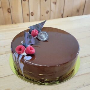 Bavaroise à la framboise et mousse chocolat sur une base croustillante praliné amande-noisette et brownies. Format de 8 parts.